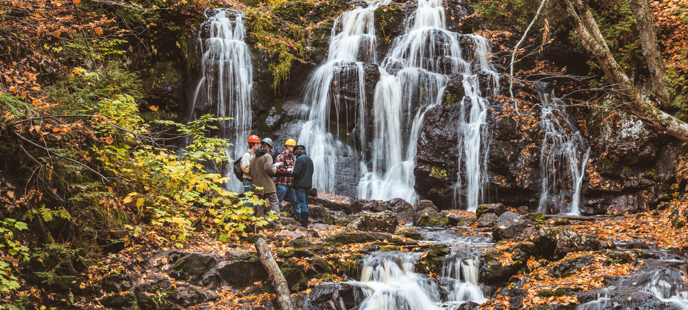 4 people studying a waterfall