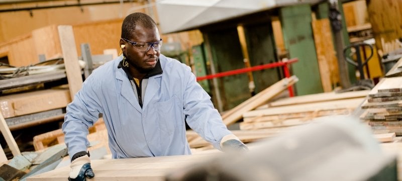 Person with protective clothing on cutting wood on a circular saw