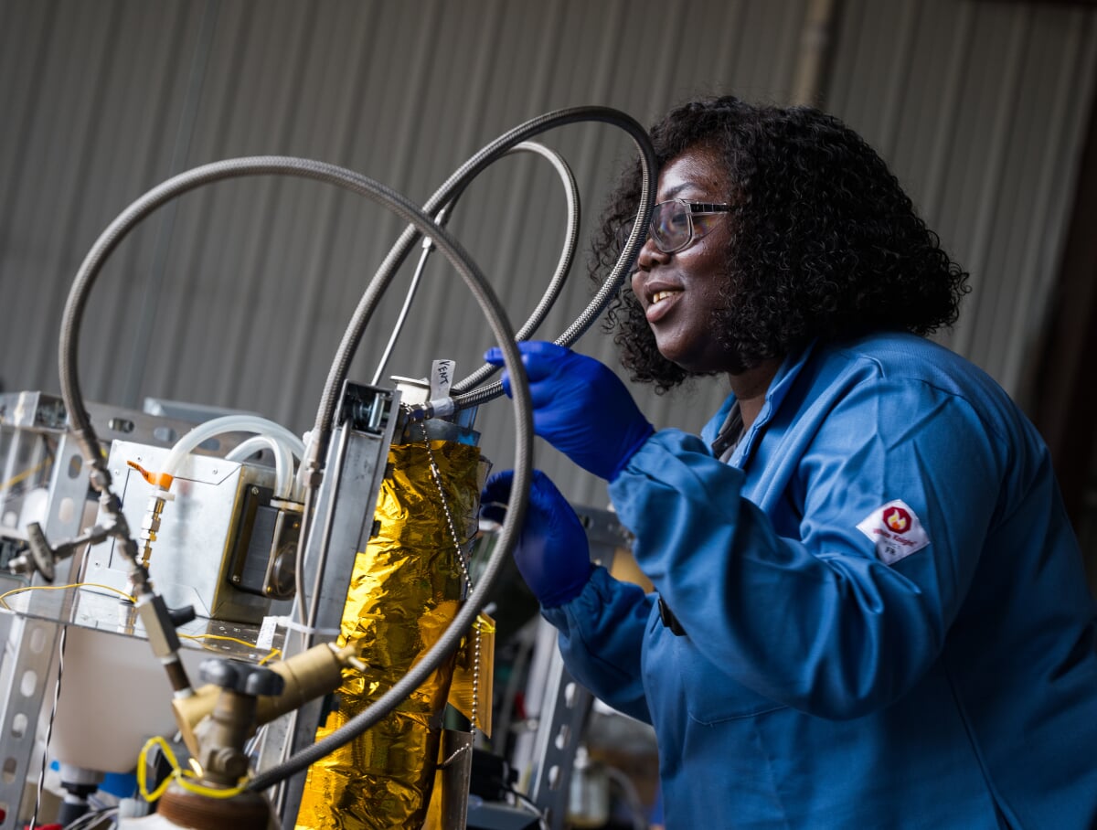 Graduate student working a a piece of lab equipment.