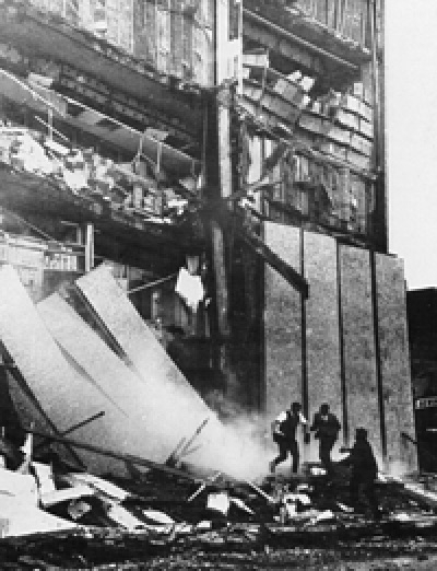 Men running from a collapsed building.