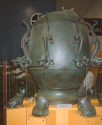 Bronze weathercock with eight dragons arranged around the roughly egg-shaped volume.