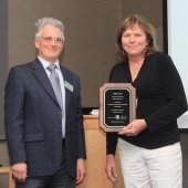 Aleksey Smirnov and Terre Lane stand with Terre's plaque