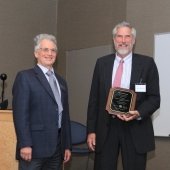 Brian Schwanitz holds his new plaque next to Aleksey Smirnov, both are smiling