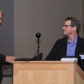 Brian Schwanitz and Greg Waite shake hands at the podium