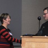 Greg Waite shaking hands with Mary Herrmann-Foley