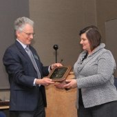 Aleksey Smirnov hands Julie Marinucci her academy plaque