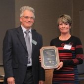 Aleksey Smirnov and Mary Herrmann-Foley pose with Mary's plaque