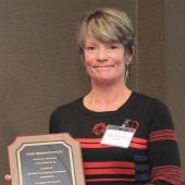 Mary Herrmann-Foley holding plaque