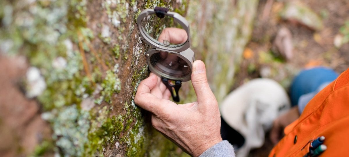 Researcher using a device against rock to measure