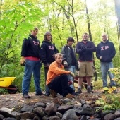 Sigma Rho members standing on a trail in the woods.