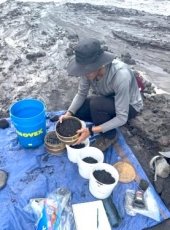 Brendan Harvile with rock samples in buckets.