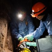 Two mining engineering researchers in the mine with protective gear.