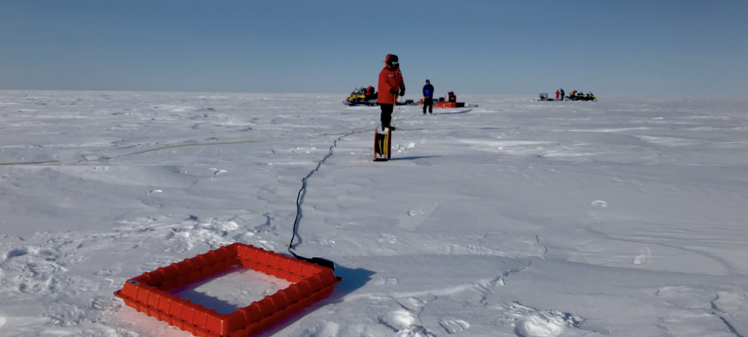 Researchers with geophysics equipment on the ice of Lake Superior.