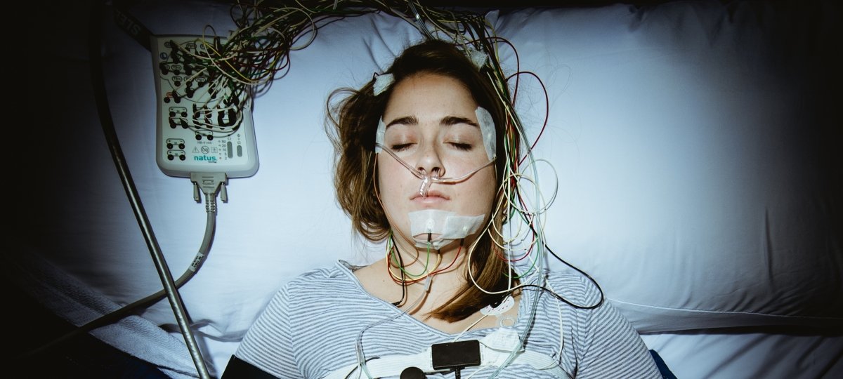 Person sleeping connected to monitoring equipment.