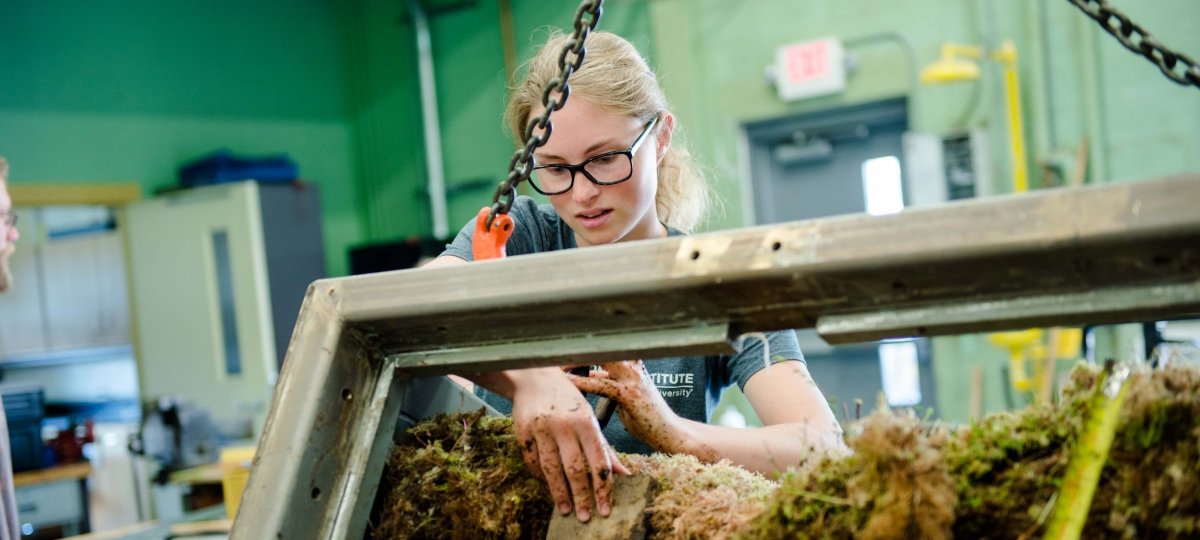 Female student working with a peat moss sample.