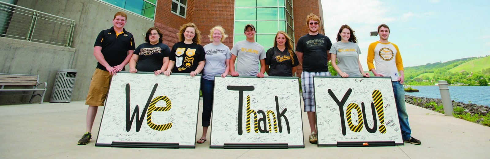 Students holding placards that say "We thank you."