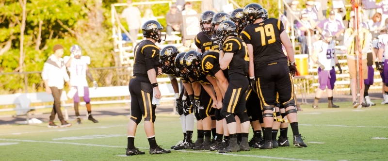 Michigan Tech football team huddling on Sherman Field.