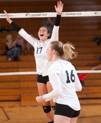 Two volleyball players celebrate a point.