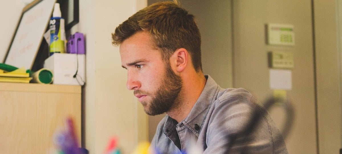 Young man working on his online course while in his office.