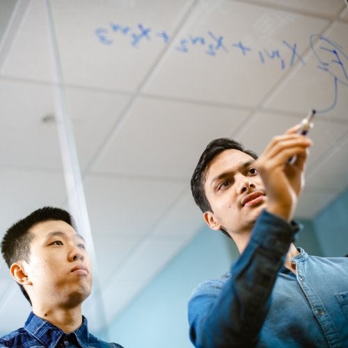 Two guys figuring out a math problem.