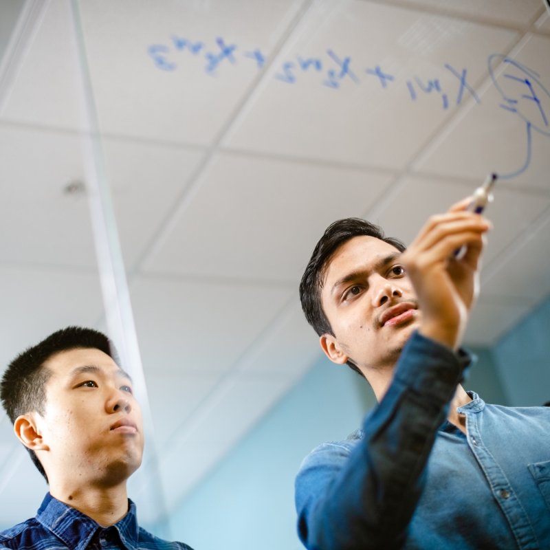 Two guys figuring out a math problem.