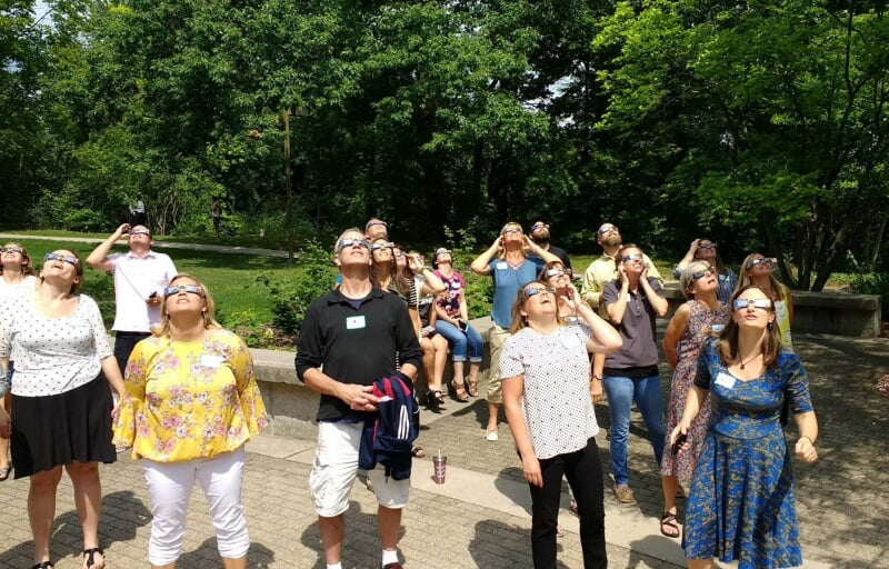 Teachers staring at the sun while wearing eclipse glasses