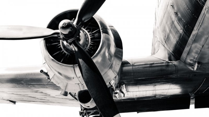 Close up of a plane propellor and the wings of a plane.