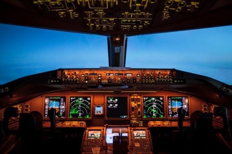 The lit-up control panel of an airplane flying at night.