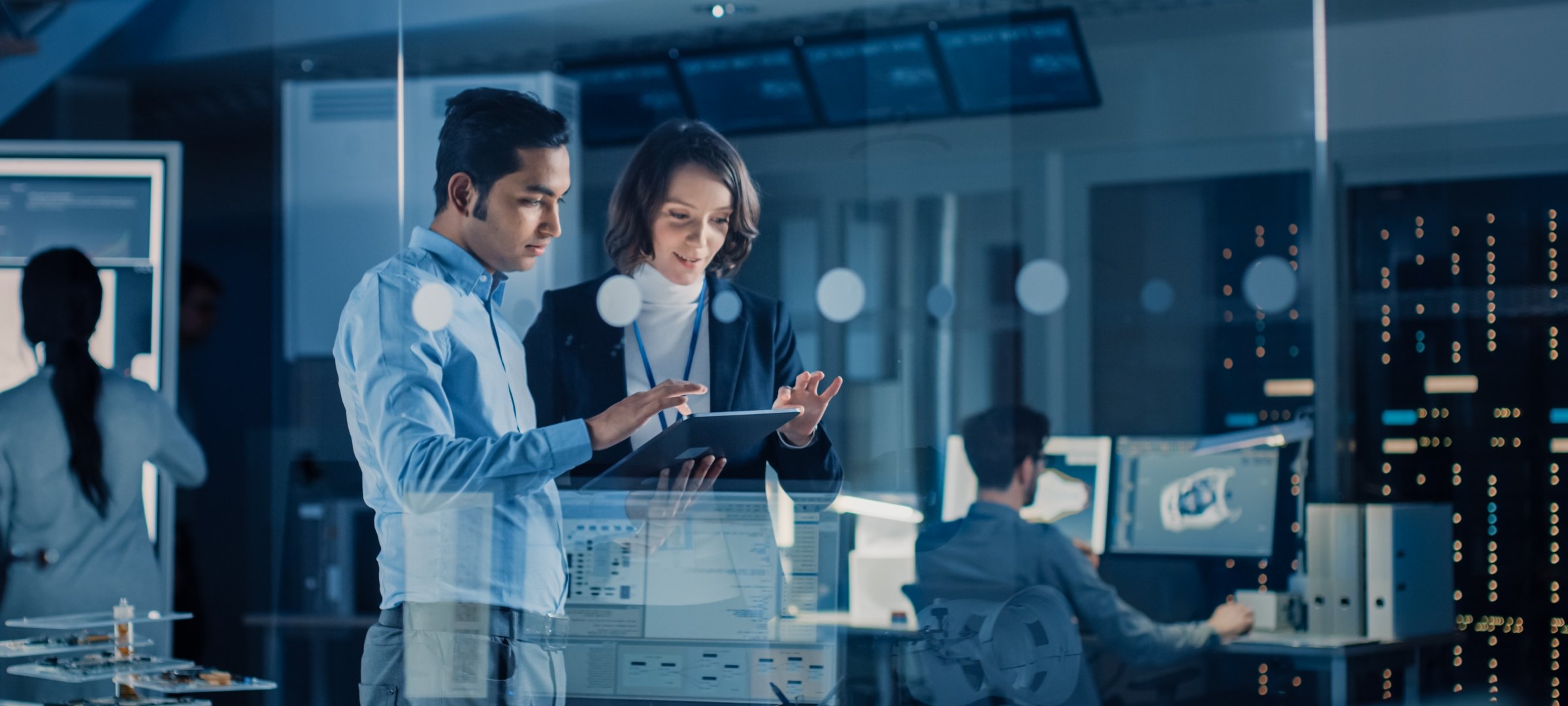 A female and male professional work on a cybersecurity problem while in their tech company.