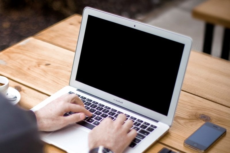 Hands of a student working at a computer.