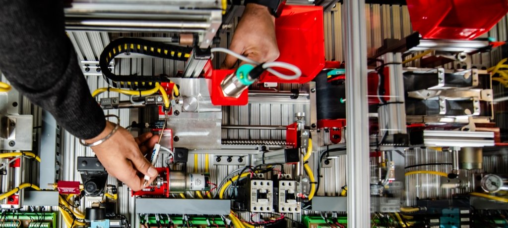 Researcher leaning over a piece of equipment making adjustments.