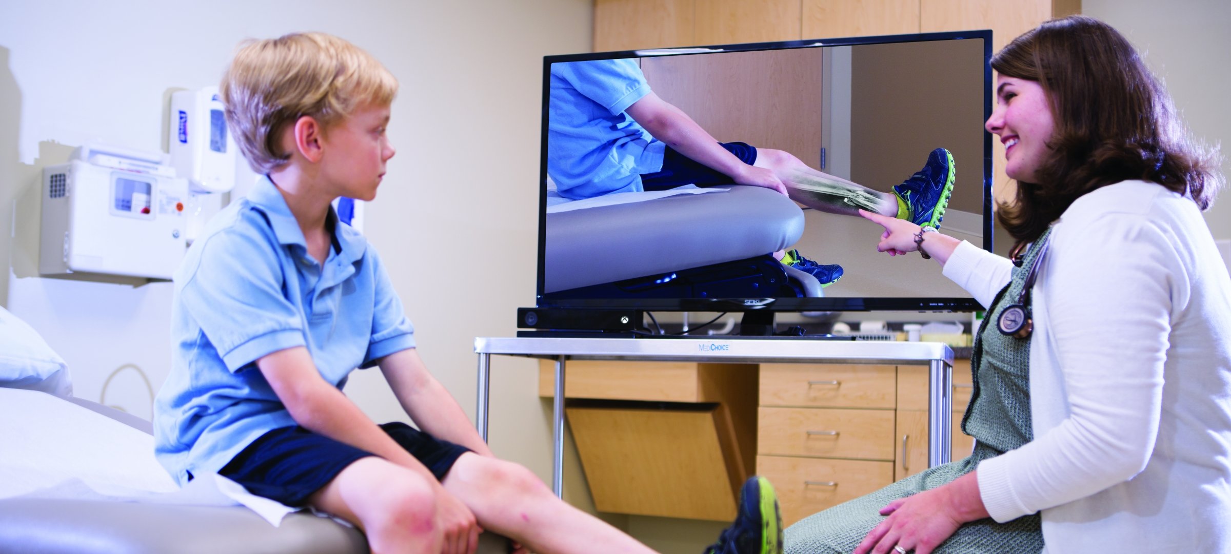 Health professional with a patient. She explains a leg injury.