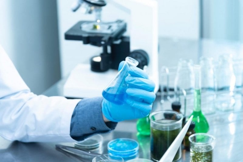 A researcher in a lab working on a drug.