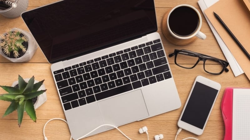 Computer and phone on a desk, meant to symbolize two devices connected to the IoT.