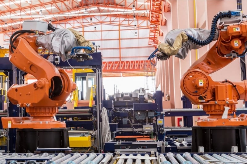 Two giant organic robotic arms in a factory setting.