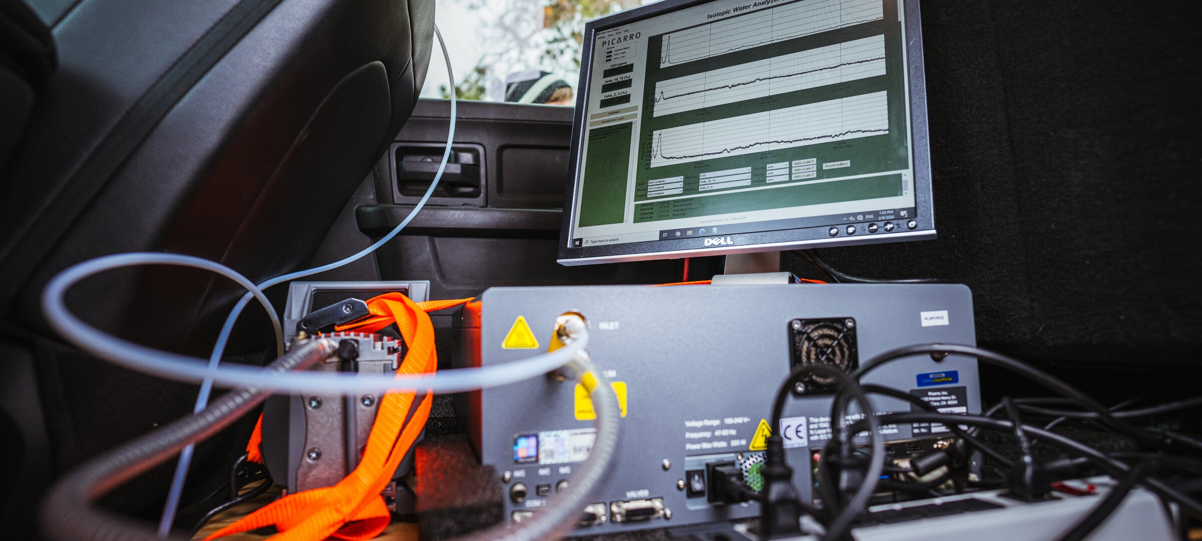 Sensor equipment and a computer screen displaying data sit in the back set of a truck.