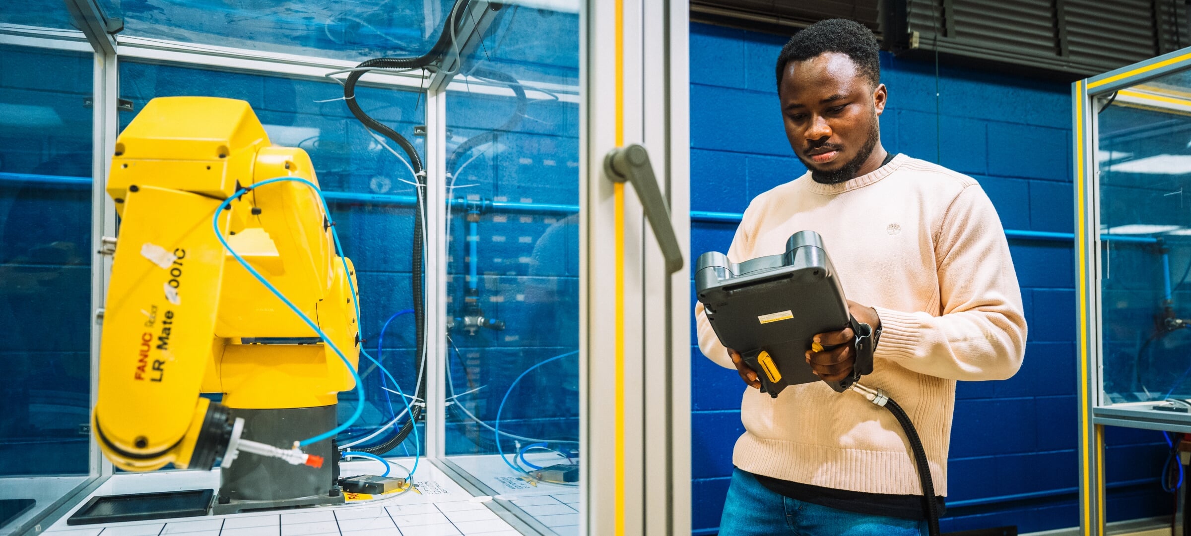 Grad student operating a robotic arm in a lab