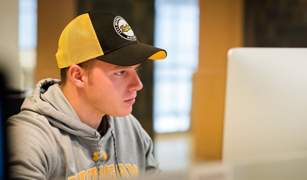 A student wearing MTU gear works at a computer.