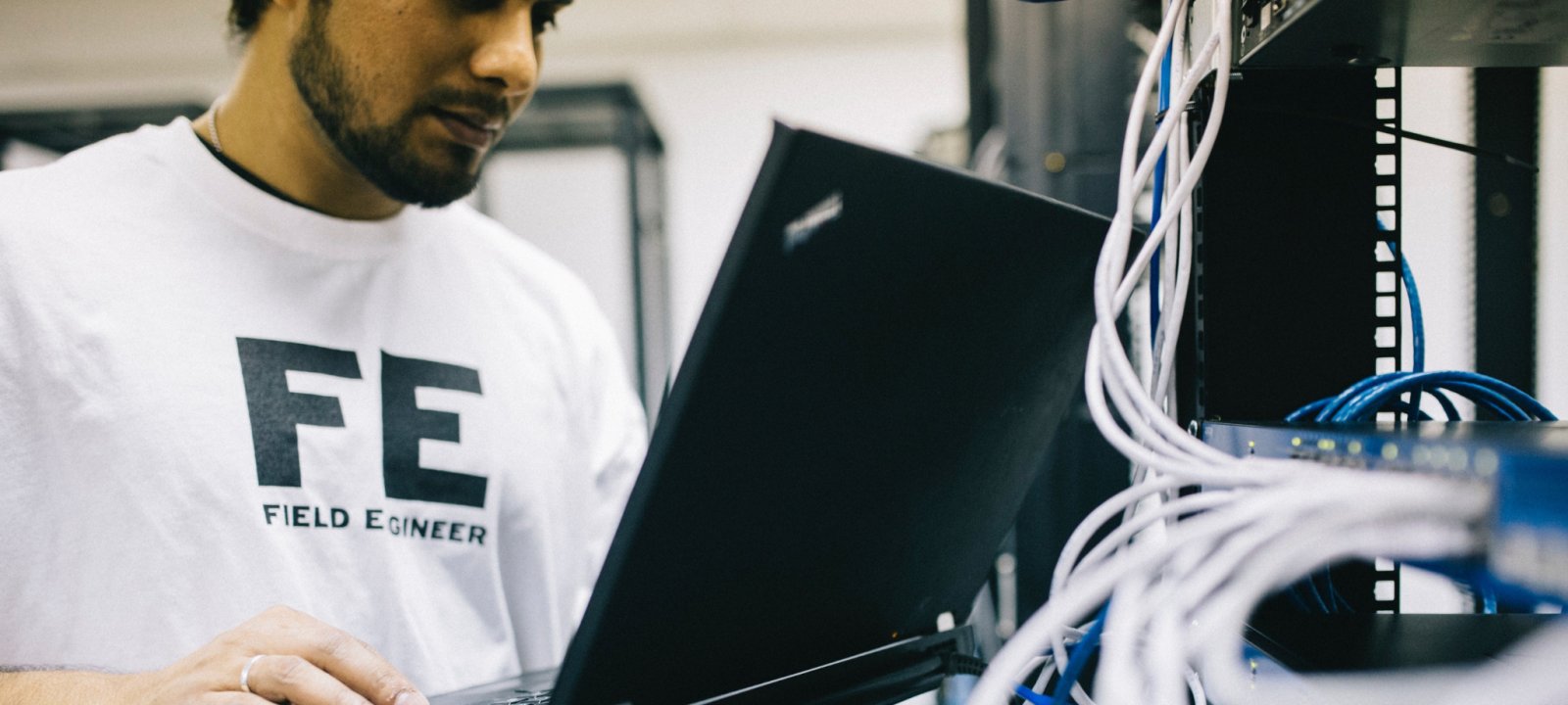 An engineer works on a laptop in an electrical and computing lab.