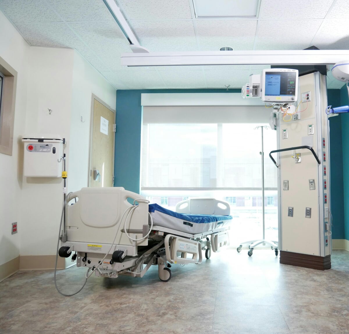 An empty hospital room with medical equipment.