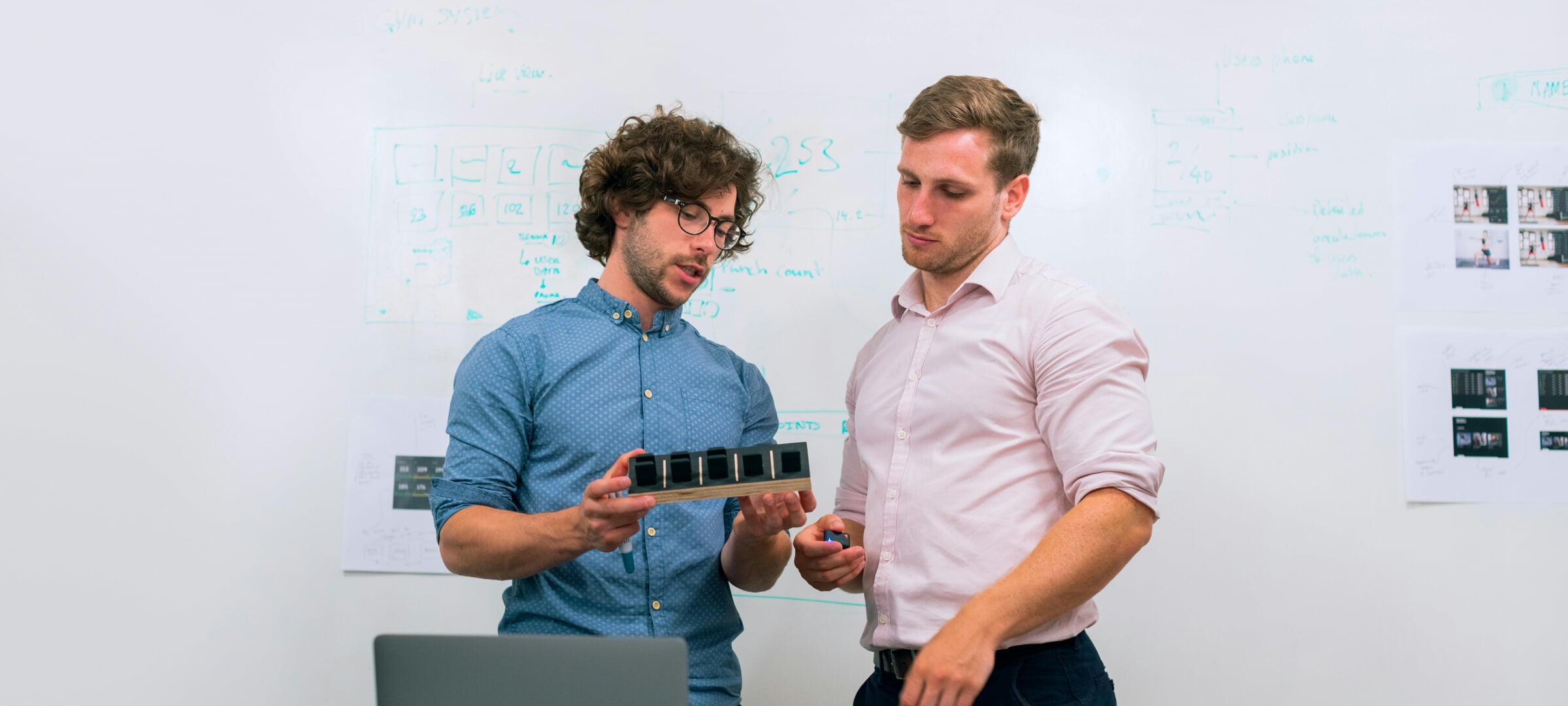 An engineer and a business professional look over a prototype of a product