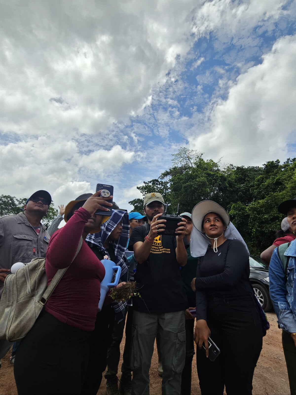 Parth Bhatt in the field with Suriname students while teaching a drone workshop.