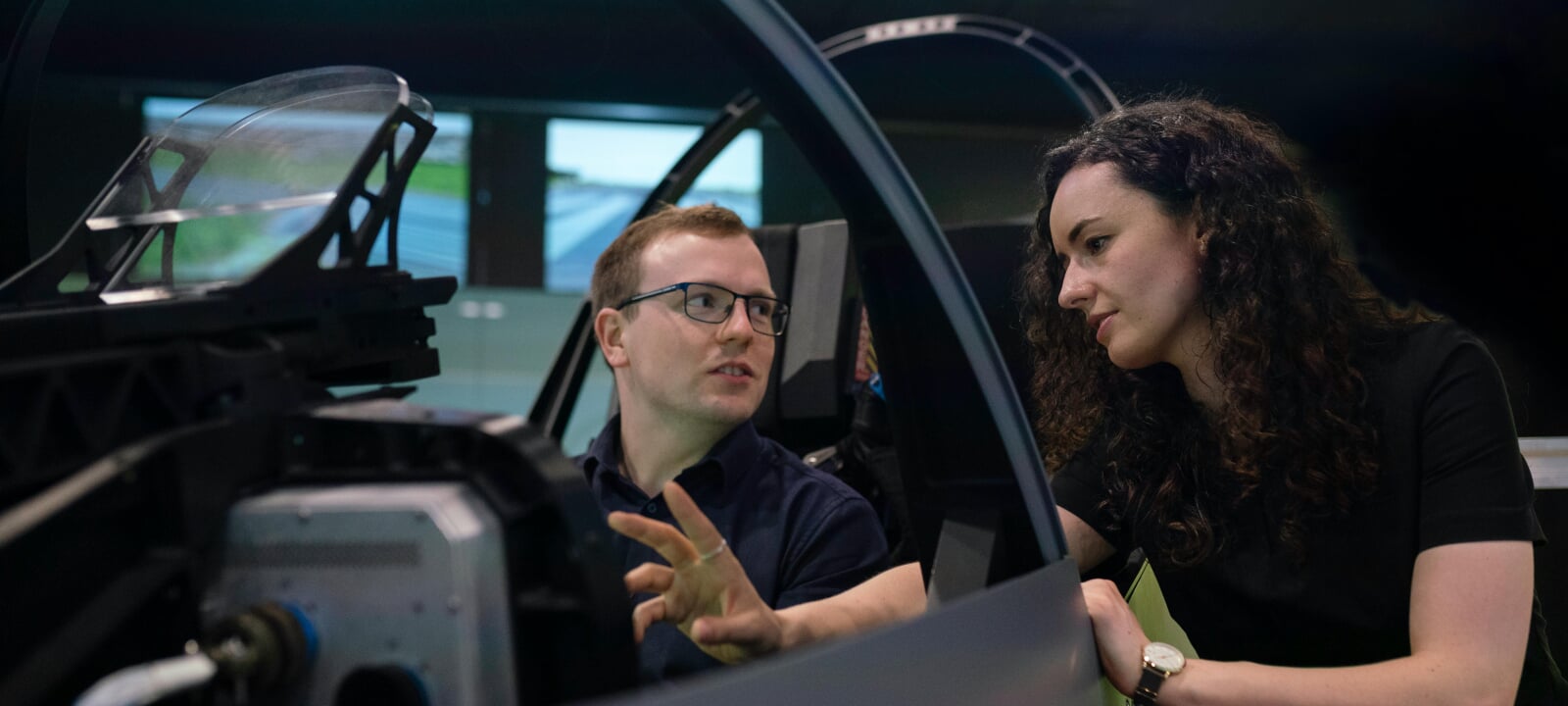 Two engineers in an aircraft frame having a discussion.
