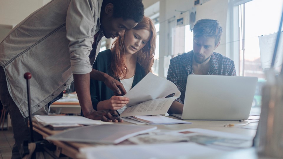 Young professionals working around a desk.