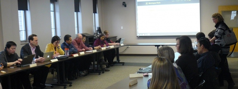 Graduate faculty council members sitting at a conference table.