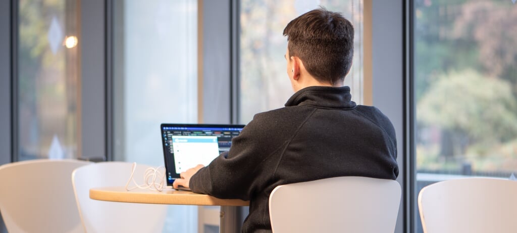 student in bright library studying at computer