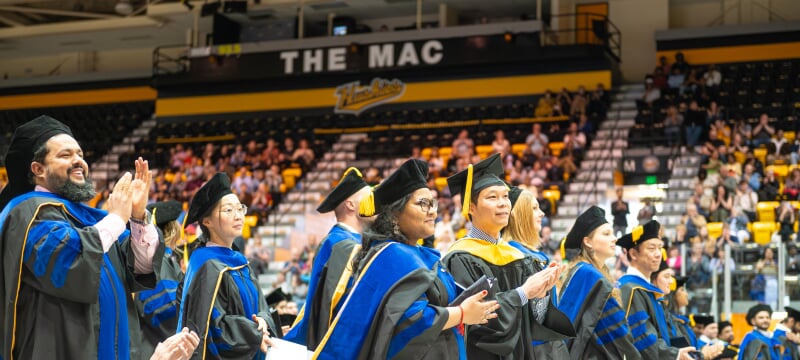 hooded students at commencement ceremony