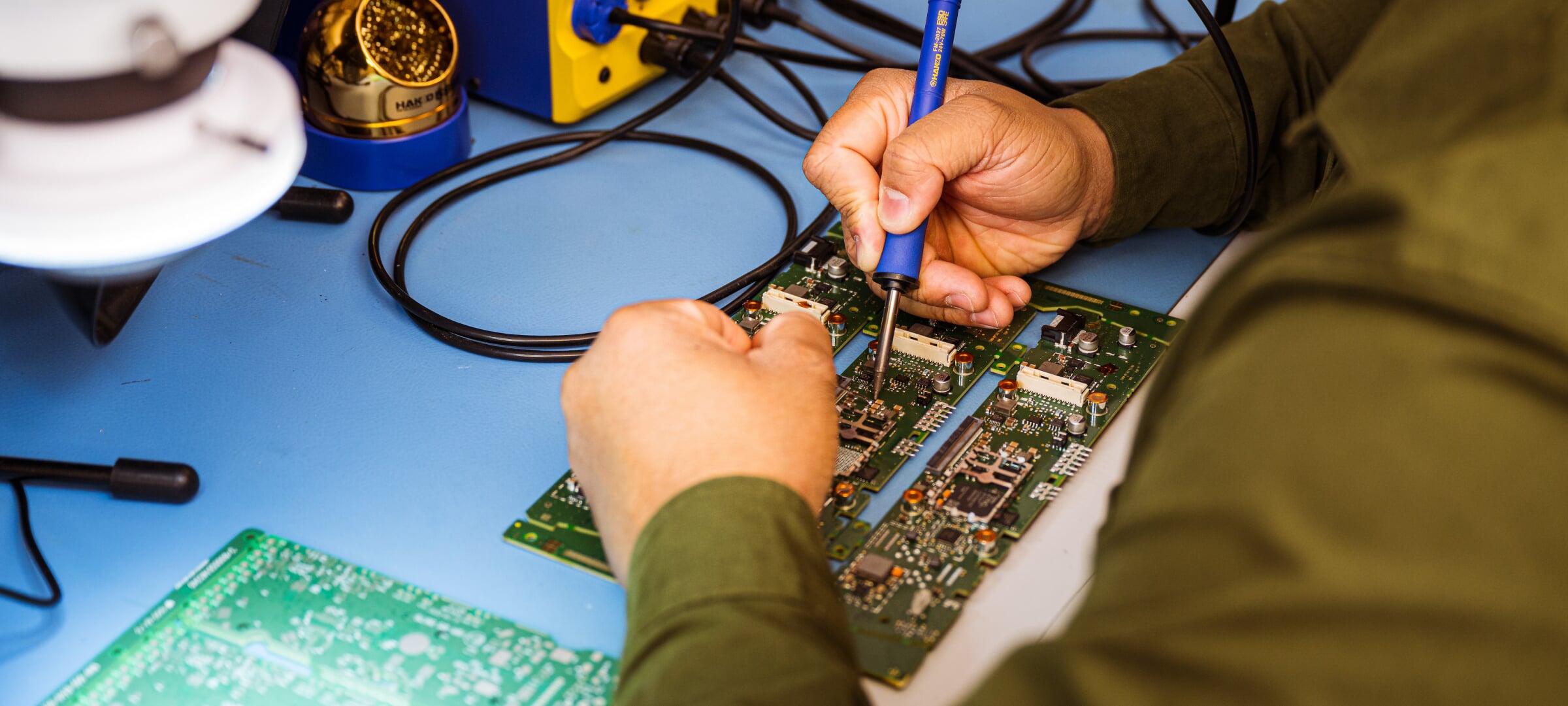 Hands soldering a set of circuit boards.