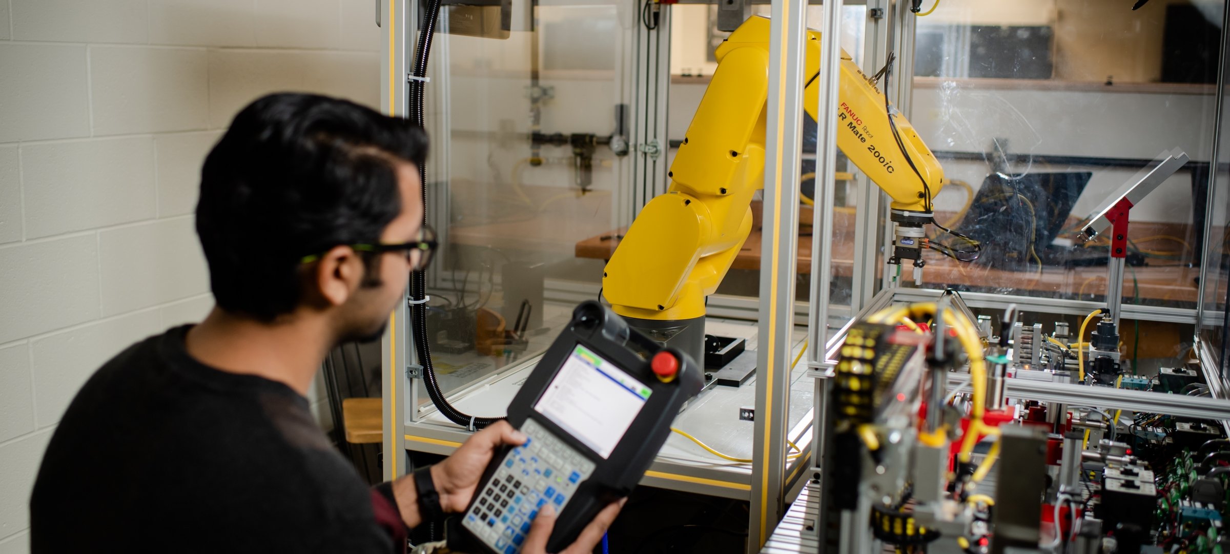 Grad student operating a robotic arm in a lab