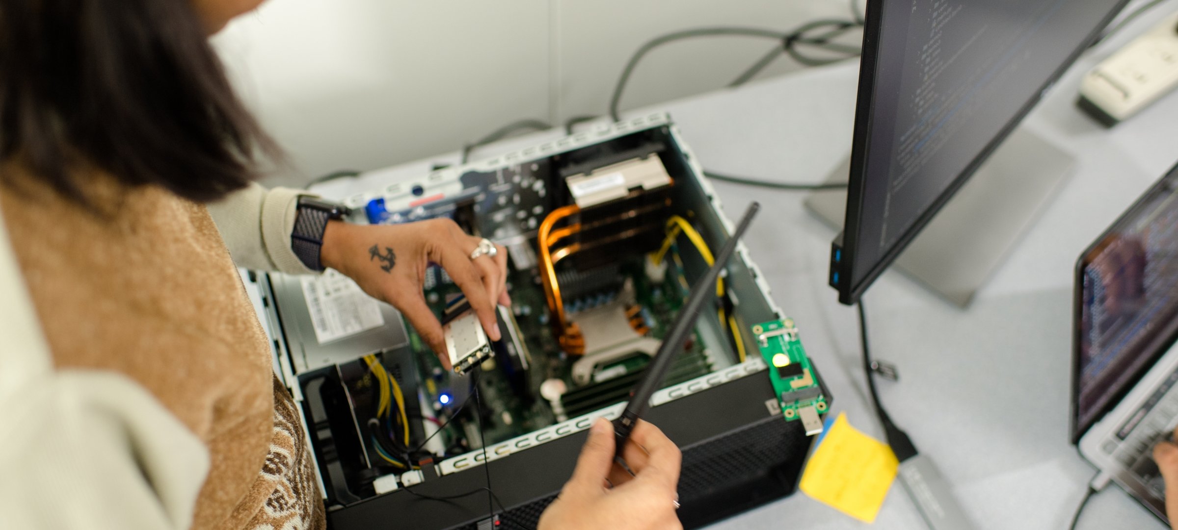 Graduate student testing the inside of computer.